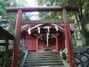 笹森稲荷神社境内から見上げる朱色の鳥居（神明鳥居）と拝殿と石垣。